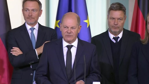 Olaf Scholz mit seinen Regierungspartnern bei einer Rede.