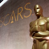 Eine goldene Oscar-Statue neben dem Schrifzug "Oscars"