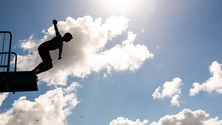 Ein Schüler kurz vor dem Absprung von einem Sprungbrett ins Schwimmbecken. Am 03.07.2019 werden in Niedersachsen und Bremen in den Schulen die Zeugnisse vergeben.