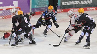 Spieler der Pinguins und der Tigers spielen auf dem Eis.