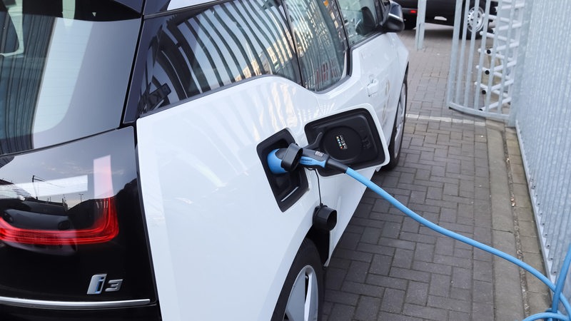 Nahaufnahme einer elektrischen Ladung bei einem Auto, die sich mit Energie auflädt