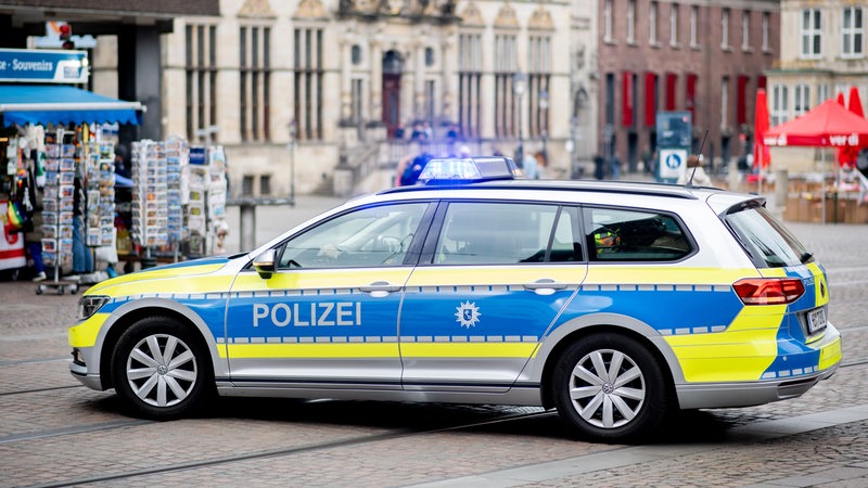 Ein Einsatzfahrzeug der Polizei steht auf dem Marktplatz in der Innenstadt.