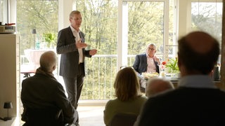 Der Spitzenkandidat der CDU, Frank Imhoff, steht im Wohnzimmer von einer Familie aus Bremen.