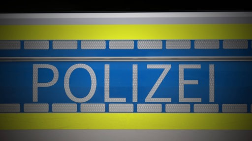 Der Schriftzug "Polizei" auf einem Streifenwagen.