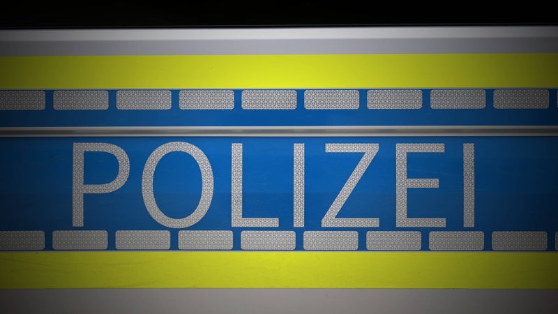 Der Schriftzug "Polizei" auf einem Streifenwagen.