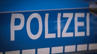 Die Seitentür eines Polizeiautos mit der Aufschrift "Polizei"