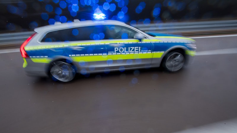 Ein Polizeiauto fährt auf einer Autobahn.