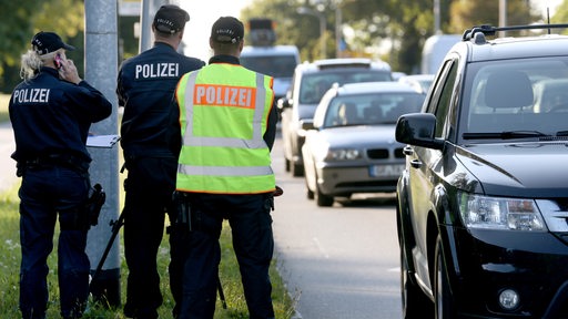 Polizisten messen mit einem Laser die Geschwindigkeit von Autos