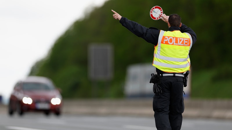 Polizist zieht Fahrzeuge zum kontrollieren aus dem Verkehr.