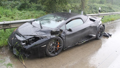 Ein Lamorghini steht auf der A27. Er ist durch einen Zusammenprall mit einem anderen Wagen und einer Leitschutzplanke kaputt.