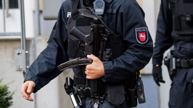 Ein schwer bewaffneter Polizist mit Maschinenpistole und schusssicherer Weste.