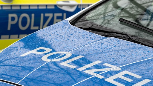 Der Schriftzug „Polizei“ auf der Kühlerhaube eines Autos