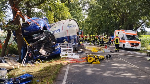 Ein Lastwagen steht mit zerstörtem Fahrerhaus neben einer Landstraße