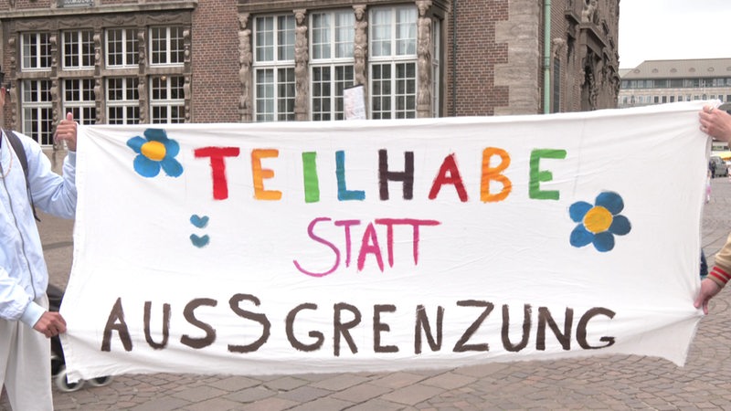 Ein Plakat mit der Aufschrift "Teilhabe statt Ausgrenzung".