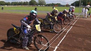 Mehrere Motorrad Rennfahrer am Startziel. 