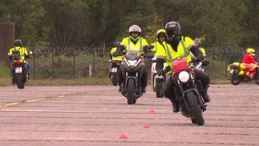Mehrere Rettungskräfte auf Motorrädern beim Fahrsicherheitstraining.