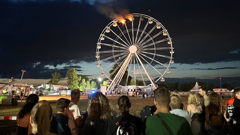 Zwei Gondeln eines Rienrads stehen in Flammen.