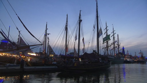 Zu sehen ist ein Schiff, welches bei Nacht im Hafen liegt.