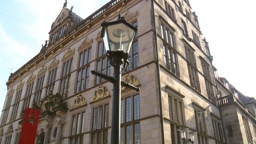 Das Gebäude des Bremer Schüttings am Marktplatz bei Sonnenschein, Straßenlaterne im Vordergrund