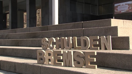 Das Wort "Schulden Bremse" wurde auf ein Treppe mit Holzbuchstaben gestellt.