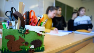 Eine Lehrerin erklärt in einer Grundschule eine Matheaufgabe.