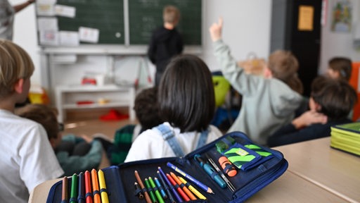 Schüler einer Grundschule arbeiten in einem Klassenzimmer an Mathematikaufgaben.