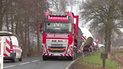 Ein Schwertransport fährt über eine Landstraße.