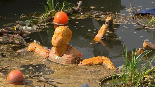 Am Tiefer schwimmt ein orangene Skulptur in der Weser.