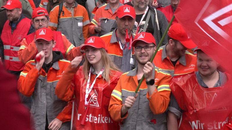 Stahlwerker protestieren mit Gewerkschaftsfahnen