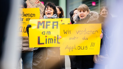 Demonstranten halten Plakate hoch