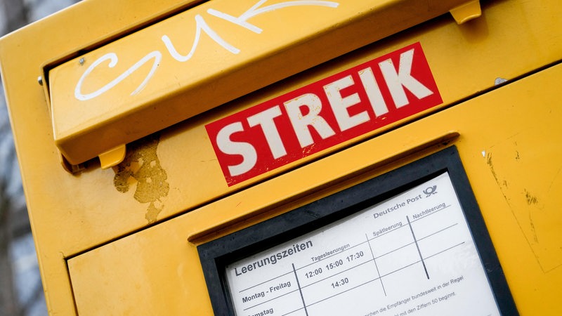 Die Gewerkschaft Verdi ruft zu Streiks bei der Post auf. An einem Briefkasten ist ein roter Aufkleber mit der Aufschrift "Streik" aufgeklebt.