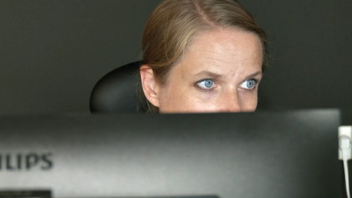 Susanne Kollmann schaut über ihr Laptop