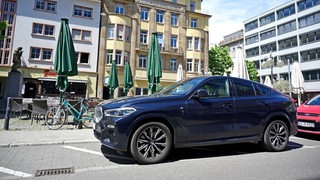 Ein SUV steht auf einem Parkplatz. Die Parkbucht ist zu klein für das Fahrzeug.