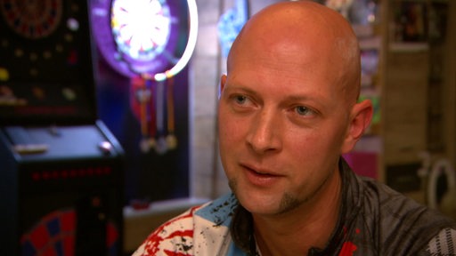 Para Darter Sven Kammann vor einer Dartscheibe.