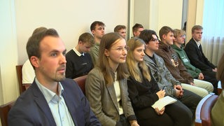 Mehrere Abiturient:innen aus Stade sitzen bei einem Symposium in Bremen.