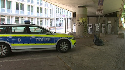 Ein Tatort am Wall: Ein Polizeiauto steht unter einer Hochstraße.