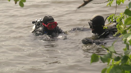 Zwei Taucher dümpeln im Wasser herum.