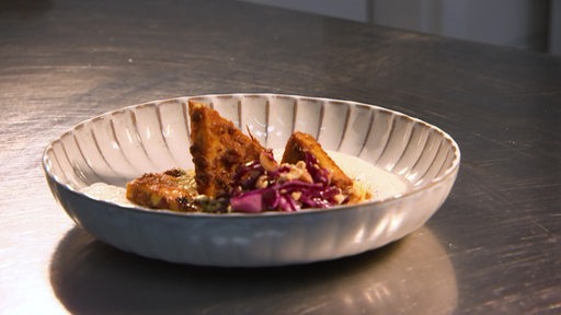 Ein Teller mit gebackenem Zitronengras Tofu steht auf einem Tisch.