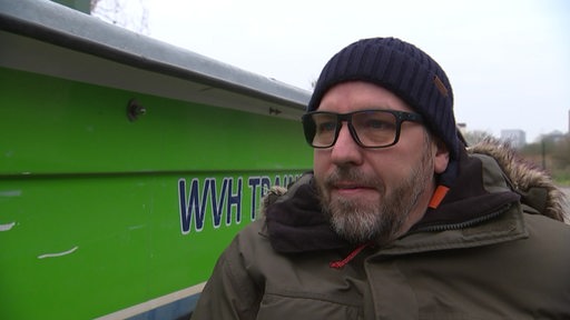  Thorsten Kutsche-Droß, der erste Rollstuhlfahrer der einen Bootsführerschein gemacht hat, neben einem grünen Boot.