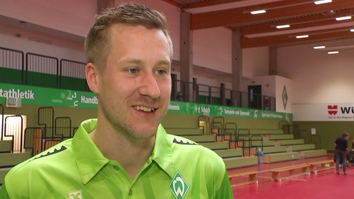 Werders Tischtennis-Profi Mattias Falck lächelt bei einem Interview nach einem Bundesliga-Spiel in der Bremer Halle.