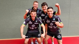 Werders Tischtennis-Mannschaft mit Kirill Gerassimenko, Mattias Falck, Andrei Putuntica und Marcelo Aguirre posiert gut gelaunt und kämpferisch im Gruppenbild.