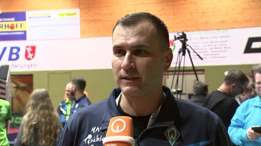 Werders Tischtennis-Trainer Cristian Tamas steht nach einem Spiel in der Halle beim Interview.