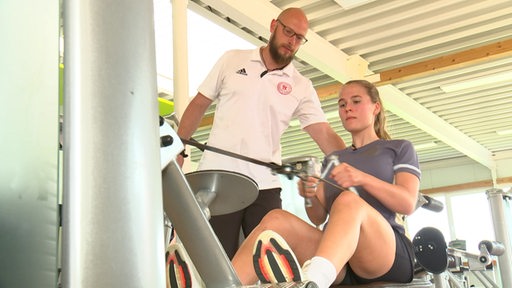 Hockey-Talent Lena Frerichs schuftet für ihr Comeback im Fitnesstudio. Mit dabei ihr Trainer.