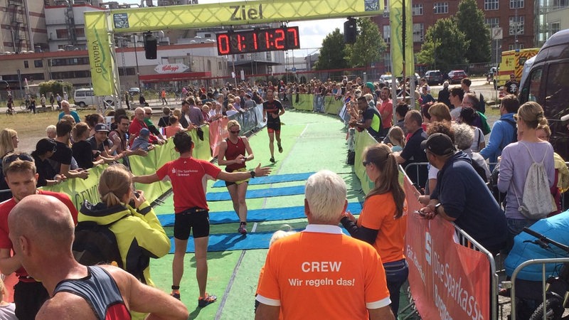 Eine Frau läuft ins Ziel ein beim City Triathlon in Bremen