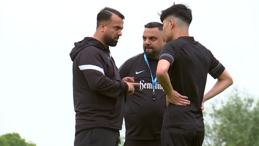 Die Tuncel Brüder im Gespräch mit einem Fussballspieler