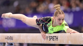Die Bremer Turnerin Karina Schönmaier liegt bei einer Übung beim DTB-Pokal in Stuttgart ausgestreckt auf dem Schwebebalken.