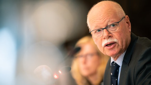 Bremens Innensenator Ulrich Mäurer sitzt während einer Pressekonferenz auf einem Podium