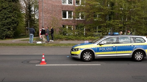 Mehrere Ermittler der Polizei stehen an einer Unfallstelle.