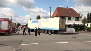 Blick auf Unfallort, Lkw steht auf Straße, Feuerwehrwagen daneben