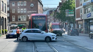 Ein Auto steht quer vor einer Straßenbahn auf den Schienen